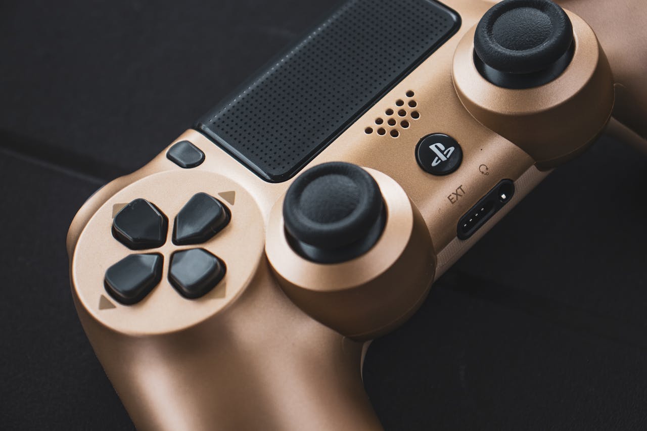 Close-up image of a gold Playstation controller showcasing its buttons and design.